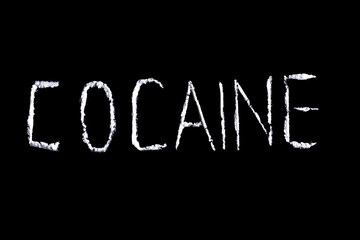 the word cocaine from white powder on a black background