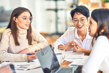 Beautiful businesswomen smiling happy. Sitting with smile on face working using laptop at the office