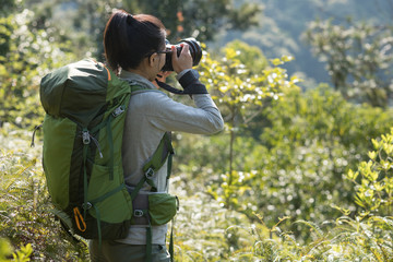 Woman photographer taking pictures in spring mountain