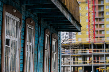 dilapidated housing, resettlement house on the background of a new house under construction