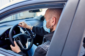 Man with protective mask adriving a car by Coronavirus pandemic quarantine
