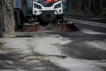 Street cleaner vehicle on the road collecting garbage and junk with brush rotation and vacuum hoover