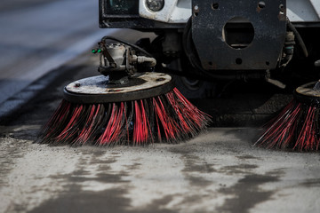 Street cleaner vehicle on the road collecting garbage and junk with brush rotation and vacuum hoover