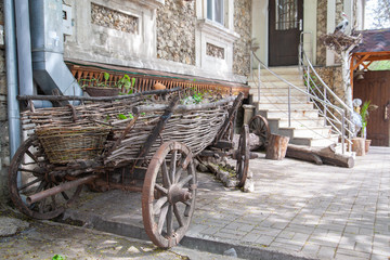 Old cart in the courtyard of a village stone house