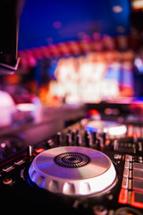 Naklejka na ściany i meble DJ Spinning, Mixing, and Scratching in a Night Club, Hands of dj tweak various track controls on dj