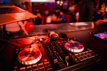 DJ Spinning, Mixing, and Scratching in a Night Club, Hands of dj tweak various track controls on dj
