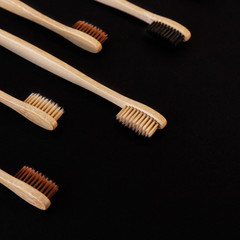 Group of eco bamboo toothbrushes, on black background. Different color. Top view, copy space....
