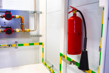 Fire extinguisher. A fire extinguisher is mounted on the wall. Fire-fighting equipment. Flame safety at the enterprise. Extinguishing equipment. Human Security. Securing the factory.