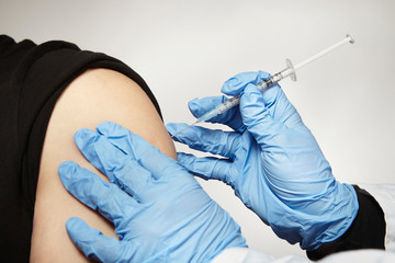 Fototapeta premium Detail of vaccinating unknown man with covid-19 disease vaccine