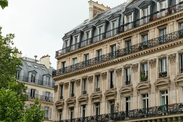 Fototapeta na wymiar Typical old Paris architecture, facades of residential buildings with roofs, chimneys and mansards, expensive real estate concept. City residents self isolation, european lifestyle