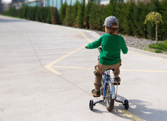 Obraz premium Small boy cycling on a little training bike on the road