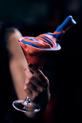 A cocktail in crystal dishes made of hair care products, red and blue with a tube. studio of beauty