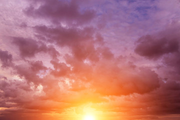 Epic dramatic sunset, sunrise on storm sky with dark clouds, orange yellow sun and sunlight