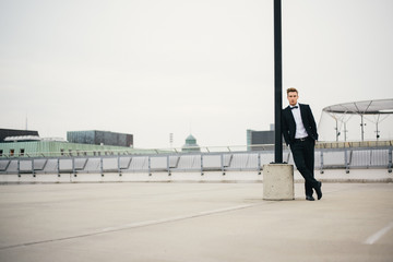 Portrait eines jungen Mannes im Anzug auf einem Parkdeck