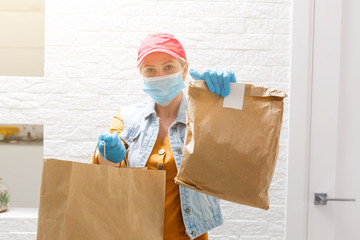 masked delivery woman delivers food during virus outbreak, coronavirus panic and pandemics.