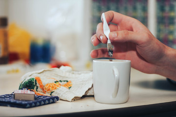 hand holds a cigarette mug on the table