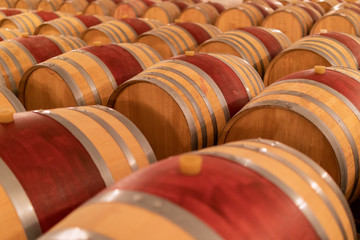 Wine barrels stacked in the old cellar of the winery. (Selective focus)