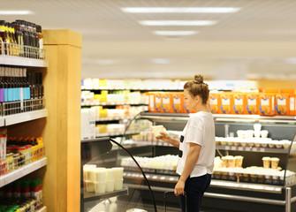 Woman choosing a dairy products at supermarket	