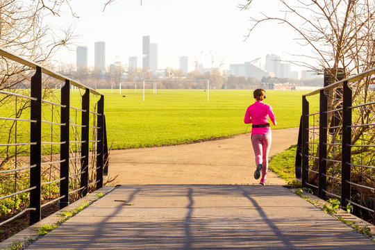 Social distancing - jogging alone in the park near Hackney Marshes, London