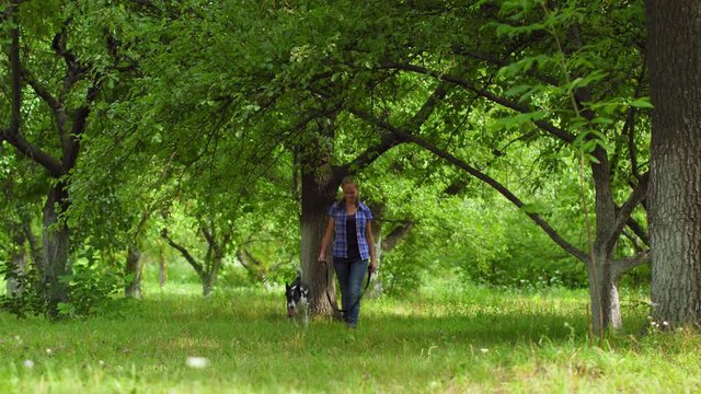 Teenage owner walke hed doge in a park or back yard