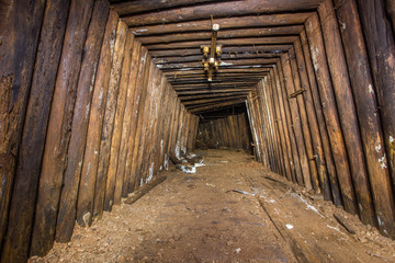 Underground abandoned bauxite ore mine tunnel with wooden timbering