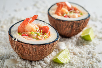 Fresh Tom Yum soup on white stones with seashells