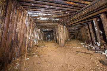 Fototapeta na wymiar Underground abandoned bauxite ore mine tunnel with wooden timbering