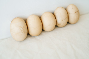 five Easter eggs trendy pastel colored with cracked shells on a white table against a white wall. minimal style. Easter concept.copy space for text