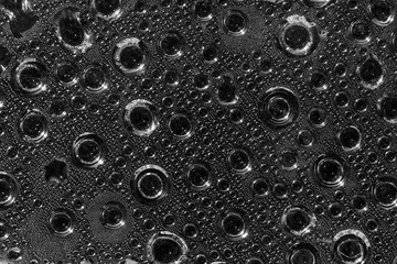 Abstract background of water drops big and small on a transparen