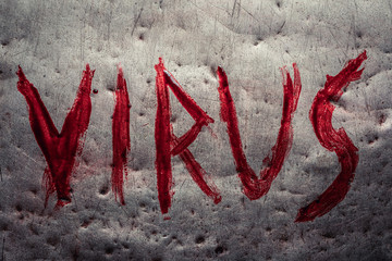 The word virus painted by blood on a metal table