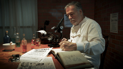 A scientist in his laboratory during the 1918 influenza pandemic called the Spanish Flu documents observations in a ledger.