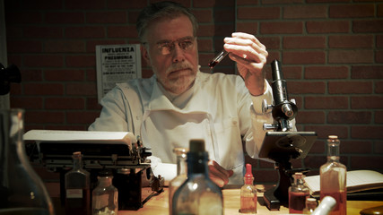 A medical scientist from the year 1918 in a private laboratory during the influenza pandemic labeled the Spanish Flu looking at a blood sample.