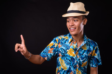 Portrait of happy young Indian tourist man with hat