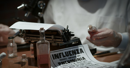 Notice of the Spanish Flu influenza epidemic of the year 1918 lying on the laboratory table of a doctor studying the virus. - obrazy, fototapety, plakaty