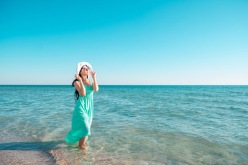Beautiful woman on the beach. Single girl in long dress.