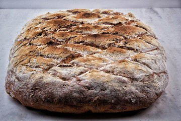 Sourdough bread with crispy crust on shelf. Bakery goods