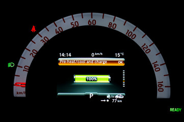 Illuminated car dashboard panel in full electric vehicle. Instrument panel with display indicating battery charge level, speedometer and seat belt reminder. Battery monitor showing full charge.
