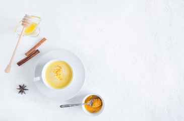 Top view image of turmeric latte over white table with copy space. Golden milk