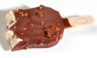 Ice cream sundae coated with chocolate on a slate board. Popsicle on a stick