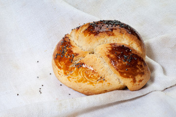 Bun with poppy seeds. Butter bun with poppy seeds on a linen napkin