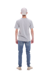 rear view. casual guy in cap reading ad on white wall