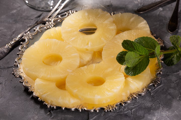Canned pineapple, cut into rings on a metal plate