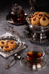 Tea and cookies in vintage utensils on a gray background