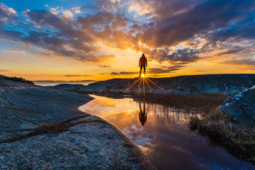 Man standing and enjoying sunset at coastline. Stora Amundön, Sweden.