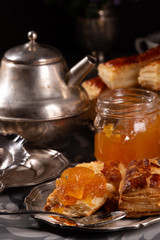 Puff pastry cookies in vintage utensils on a gray background