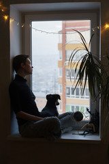 woman and dog by the window on quarantine