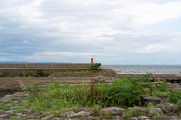 Fototapeta na wymiar 赤い灯台のある港