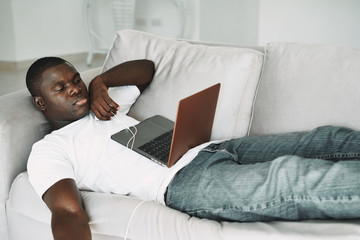 man lying on sofa with laptop