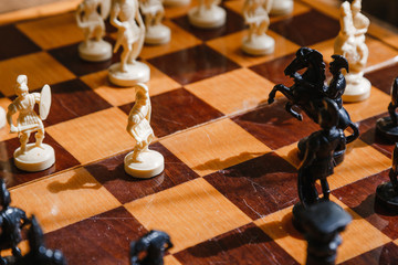 Chess white and black pieces fight on the battlefield for their king