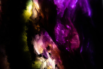 macro view, abstract background with colorful  in stone. slice of a gem with backlight